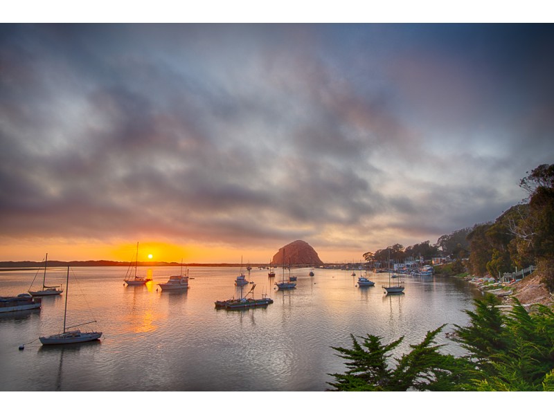 Morro Rock in Morro Bay at sunset with harbor