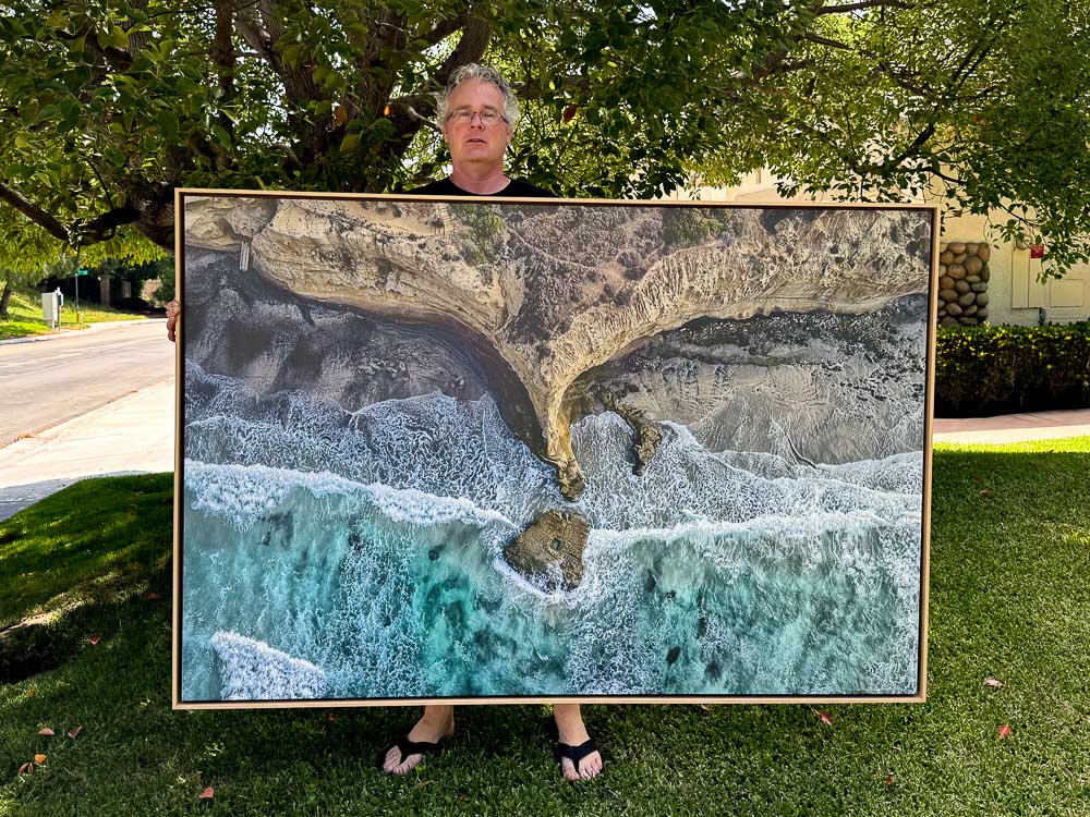 Roy holding large photo of flat rock on canvas