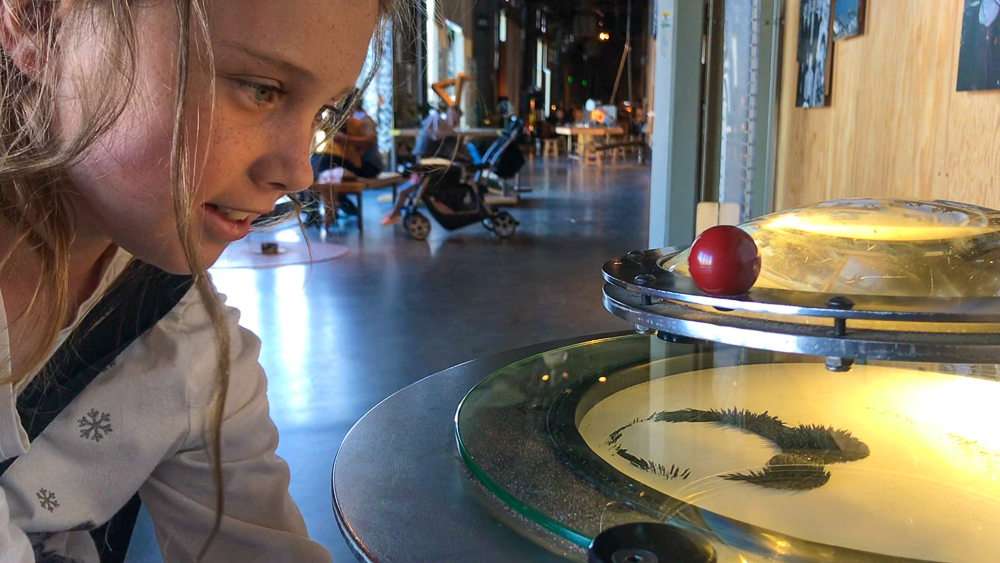 kate playing with magnets and iron particles at the exploratorium in san francisco