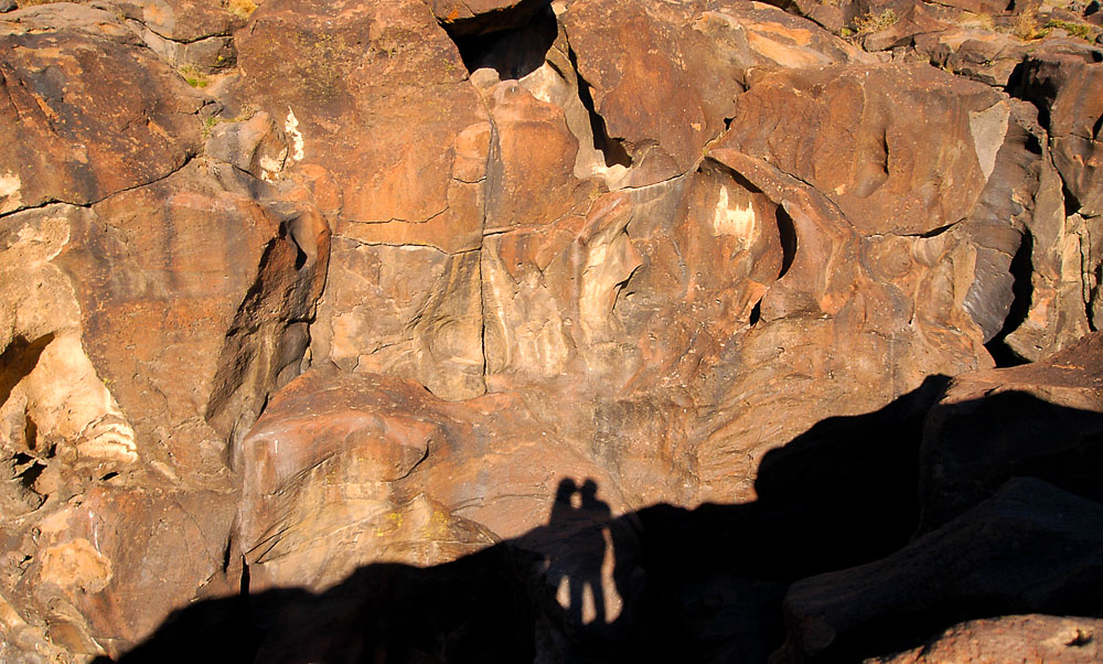 silhouettes of man and woman kissing at fossil falls in owens valley california